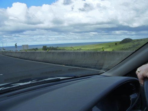 The ocean can be seen a bit to the right of the road.