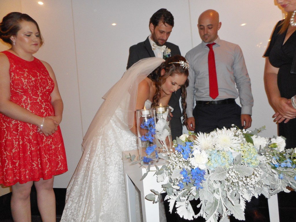 The bride signs the marriage contract in the presence of the celebrant and two witnesses.